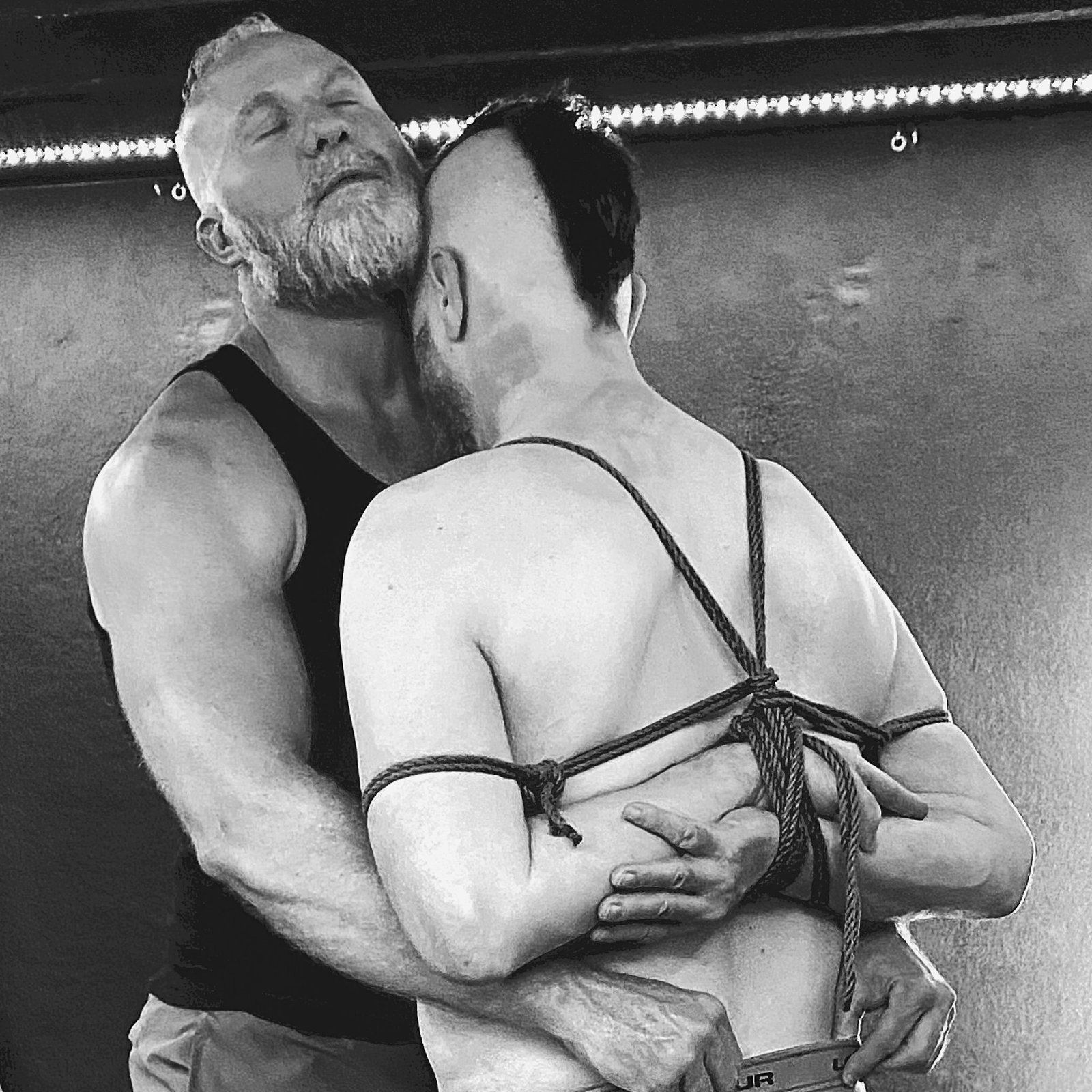 An intimate embrace within a rope harness